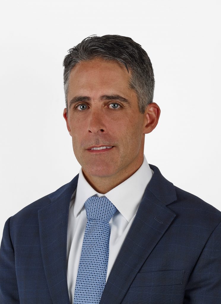 Photo of Senior Vice President, Chief Technology Officer Thomas Steele. A man wearing a navy blue jacket with white shirt and light blue tie against a white background.